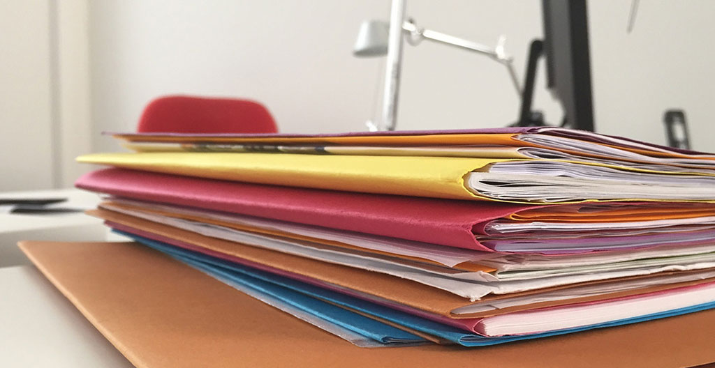 Bureau administratif municipal avec dossier de permis de construire pour abri de piscine, plans techniques et documents officiels français étalés sur le bureau